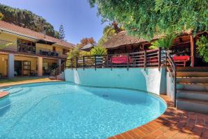 a swimming pool in front of a house at Villa Helderberg in Somerset West