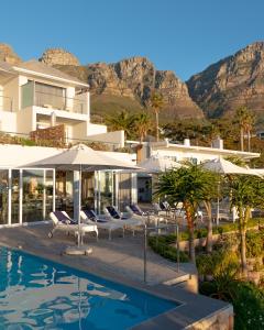 a resort with a swimming pool and mountains in the background at Ocean View House in Cape Town