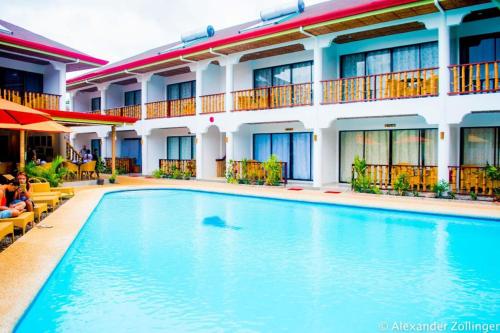 a swimming pool in front of a hotel at Alona Vida Beach Hill Resort in Panglao Island