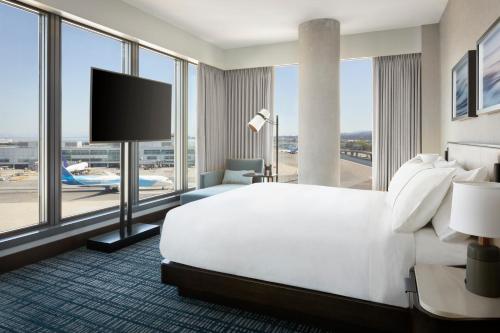 um quarto de hotel com uma cama grande e uma janela grande em Grand Hyatt at SFO em Millbrae