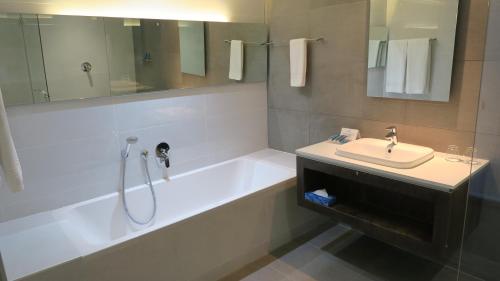 a bathroom with a tub and a sink and a shower at Lagoon Beach Hotel Apartments in Cape Town