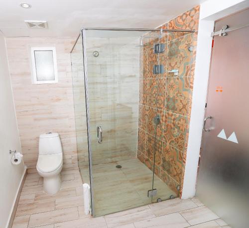 a shower stall in a bathroom with a toilet at Grand Decameron Cornwall Beach, A Trademark All-Inclusive Resort in Montego Bay