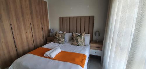 a bedroom with a bed with two towels on it at Lush Living The Blyde Riverwalk Estate Unit 101 in Pretoria