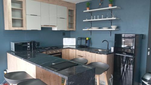 a kitchen with white cabinets and a black counter top at Durban Beachfront 10 South Apartments 1404 in Durban