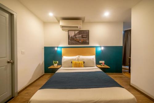 a bedroom with a large bed with a blue wall at Olive Zip Richmond Circle by Embassy Group in Bangalore