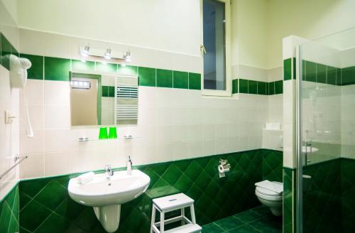 un bagno verde e bianco con lavandino e servizi igienici di Budapest Rooms Bed and Breakfast a Budapest