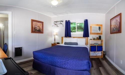 a bedroom with a blue bed and a window at Belle Isle Motel in Bar Harbor