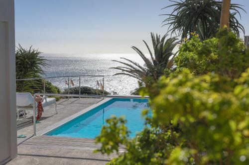 a swimming pool with the ocean in the background at Ocean View House in Cape Town