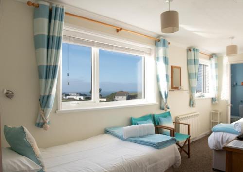 a bedroom with two beds and a window at Trevarrian Lodge in Newquay