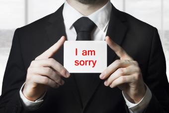 Businessman holding sign I am sorry