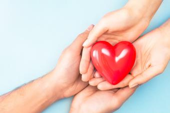 A woman and a man holding red heart