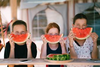 Kids eating watermelon on beach holiday