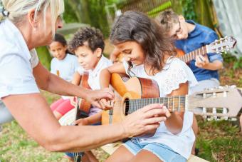 Group Of Kids Playing Guitar Outdoors