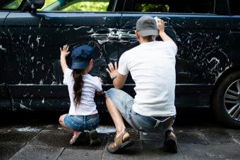 father and daughter washing a car