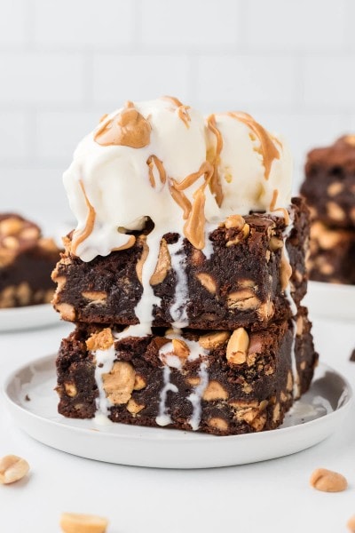 Extra fudgy Chocolate Peanut Brownies topped with vanilla ice cream and drizzled with peanut butter.