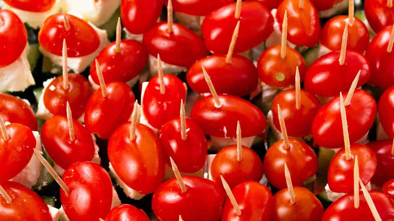 Tomato, feta, and cucumbers each neatly threaded onto a wooden skewer.