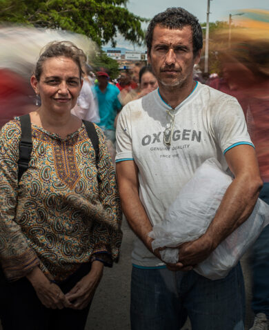 A man and a woman posing on a busy street.