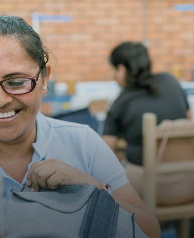 A smiling woman working in a garment factory