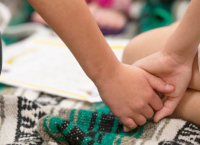 Two children hold hands after witnessing violence.