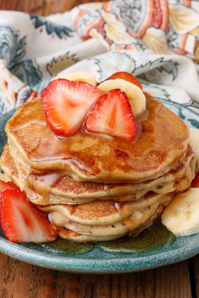 pancakes with fruit and syrups on blue plate