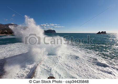 Stock Photo of Stone breakwater with breaking waves. Adriatic Sea.