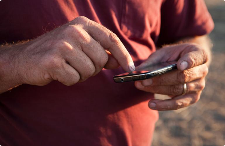 farmer holding a mobile phone in the field 