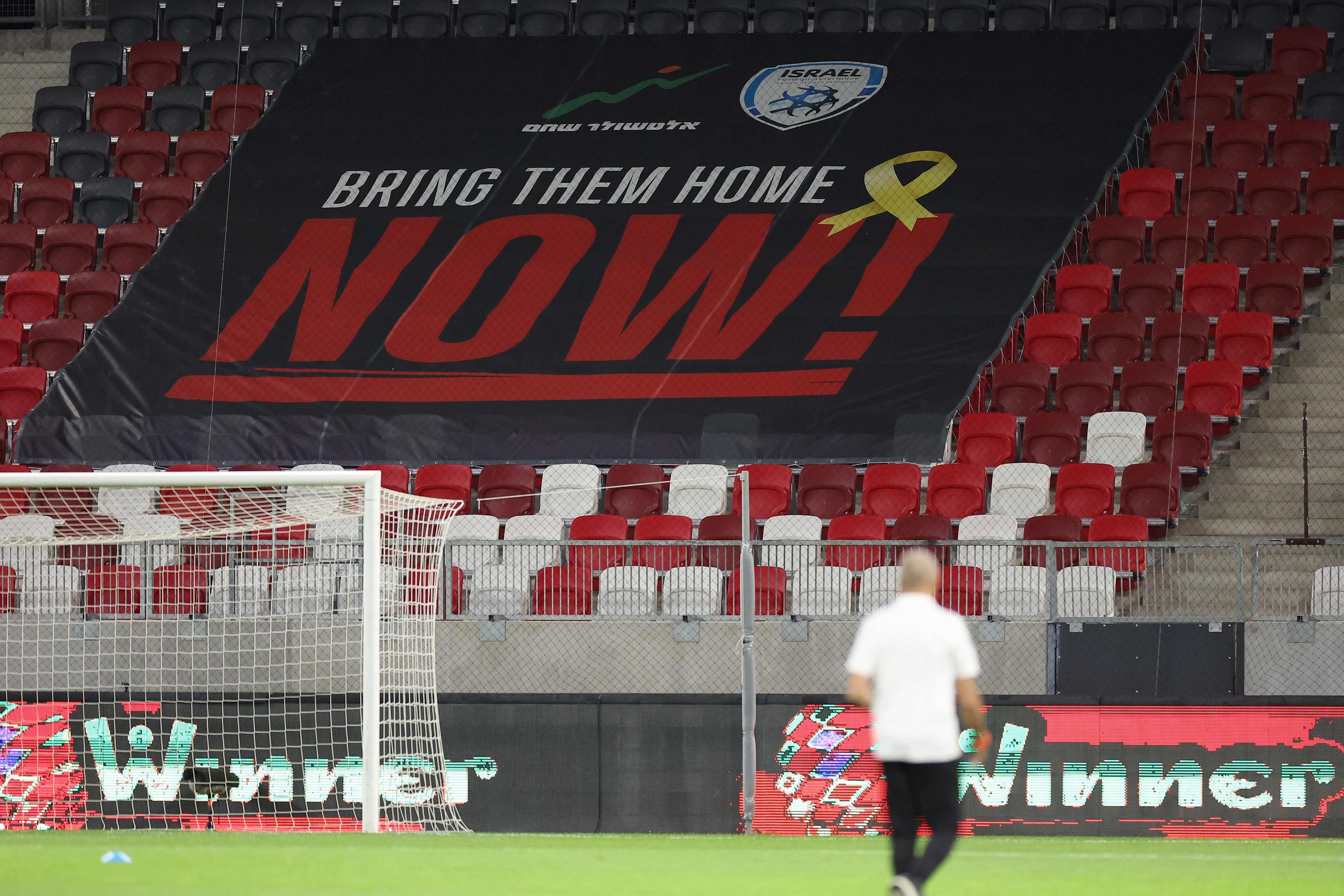 Une banderole portant l'inscription « Bring them home now », en référence aux otages toujours détenus par les militants du Hamas dans la bande de Gaza, est déployée dans l'une des tribunes vide de la Bozsic Arena où Israël affronte l'équipe de France ce jeudi, à Budapest. Photo FRANCK FIFE / AFP