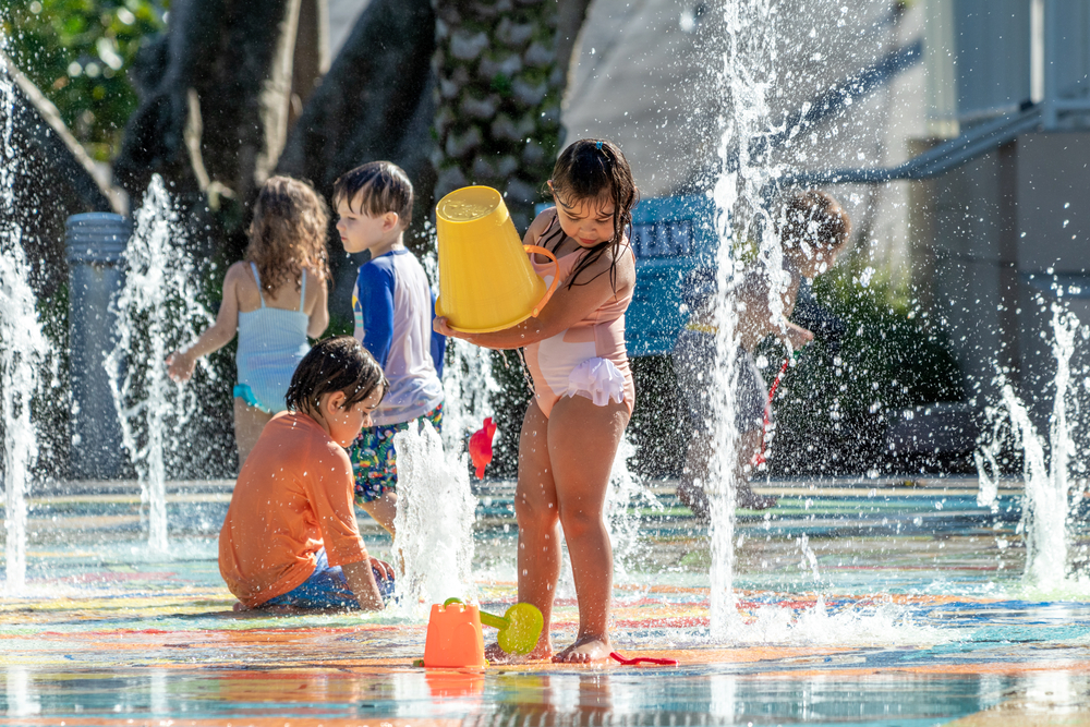 image of kids playing on spash pads inct.