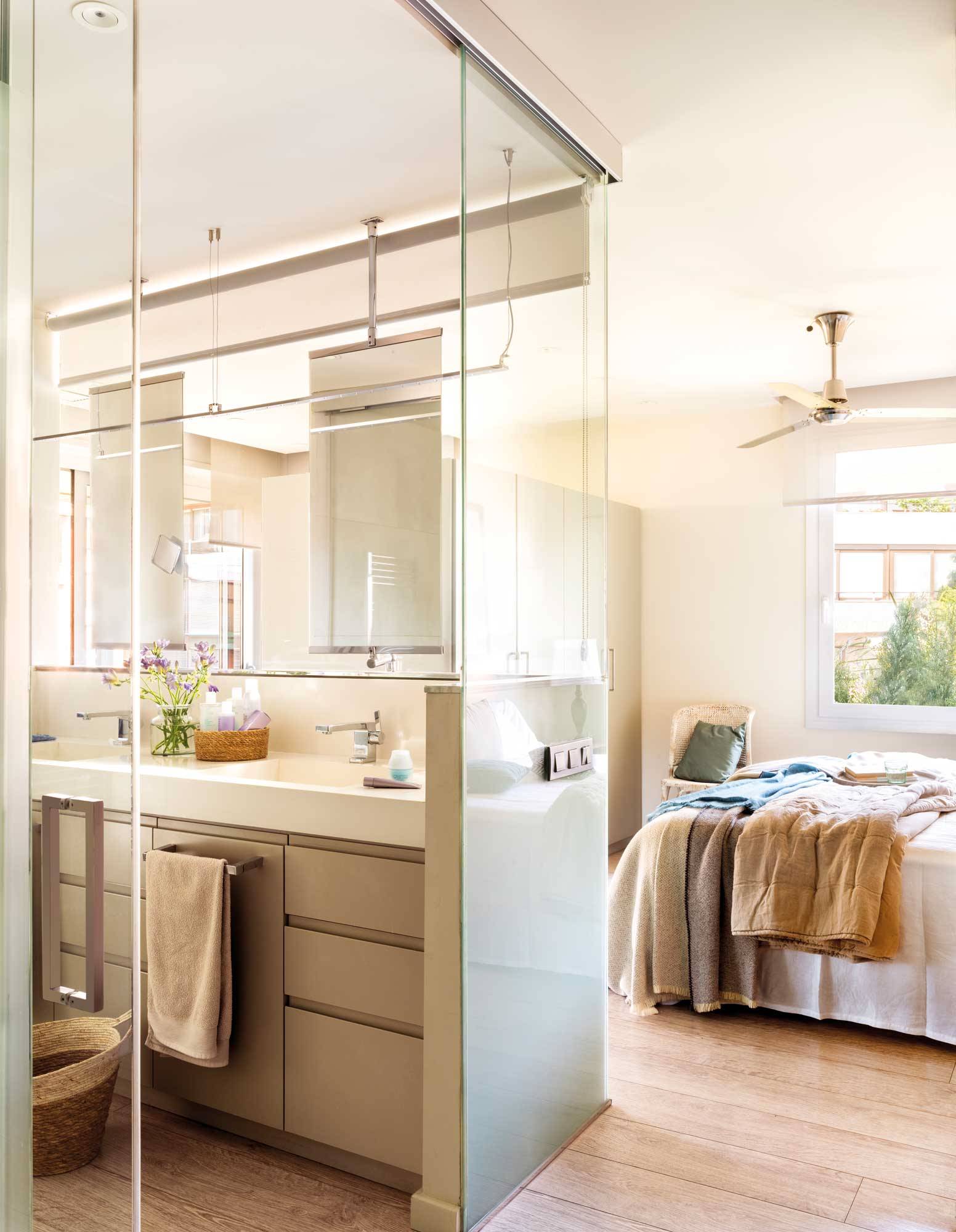 Baño separado del dormitorio con una pared de cristal. 