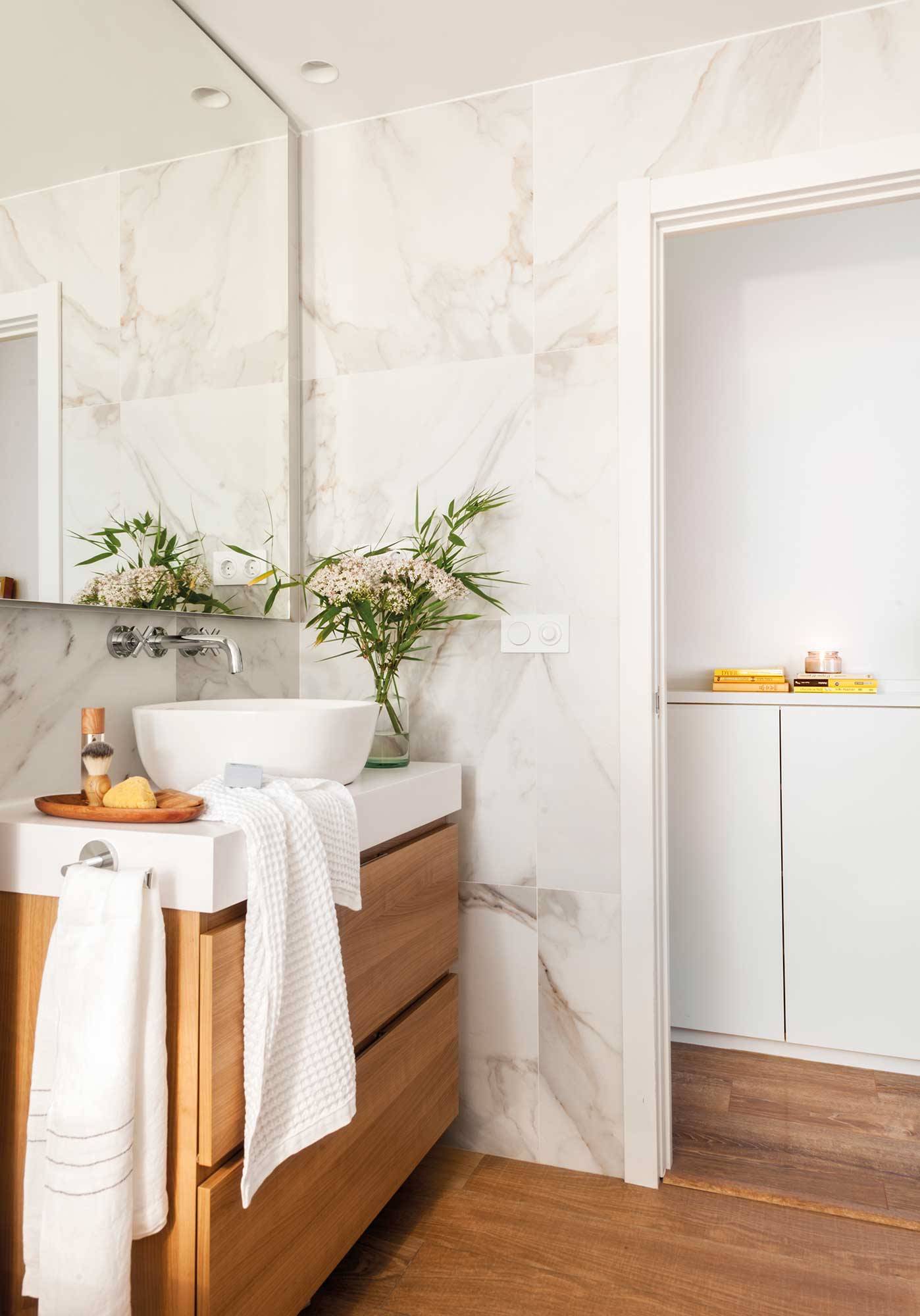 Baño clásico con mueble de madera y paderes de mármol. 