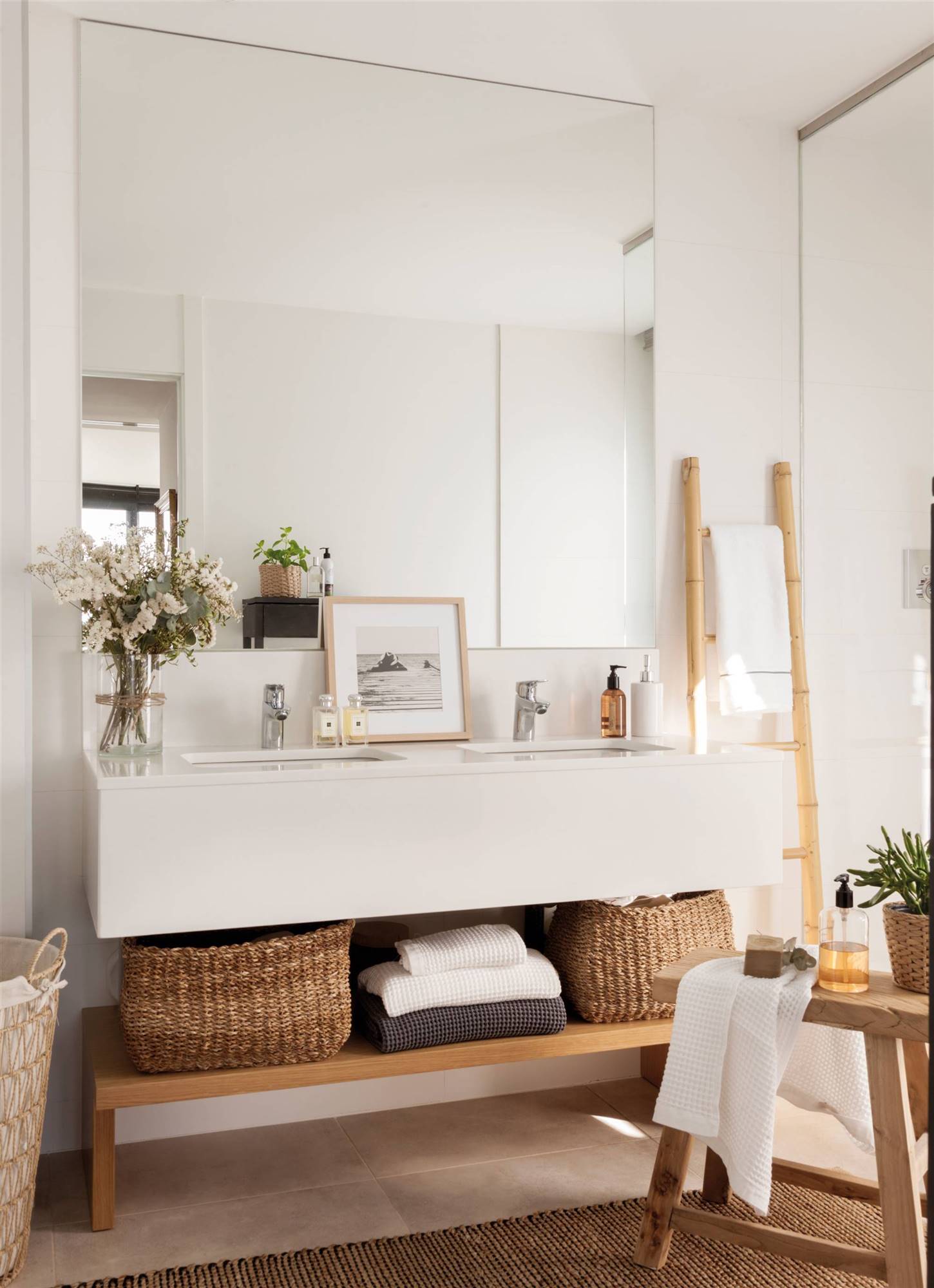 Baño con mueble de lavabo exento y banco con cestas. 