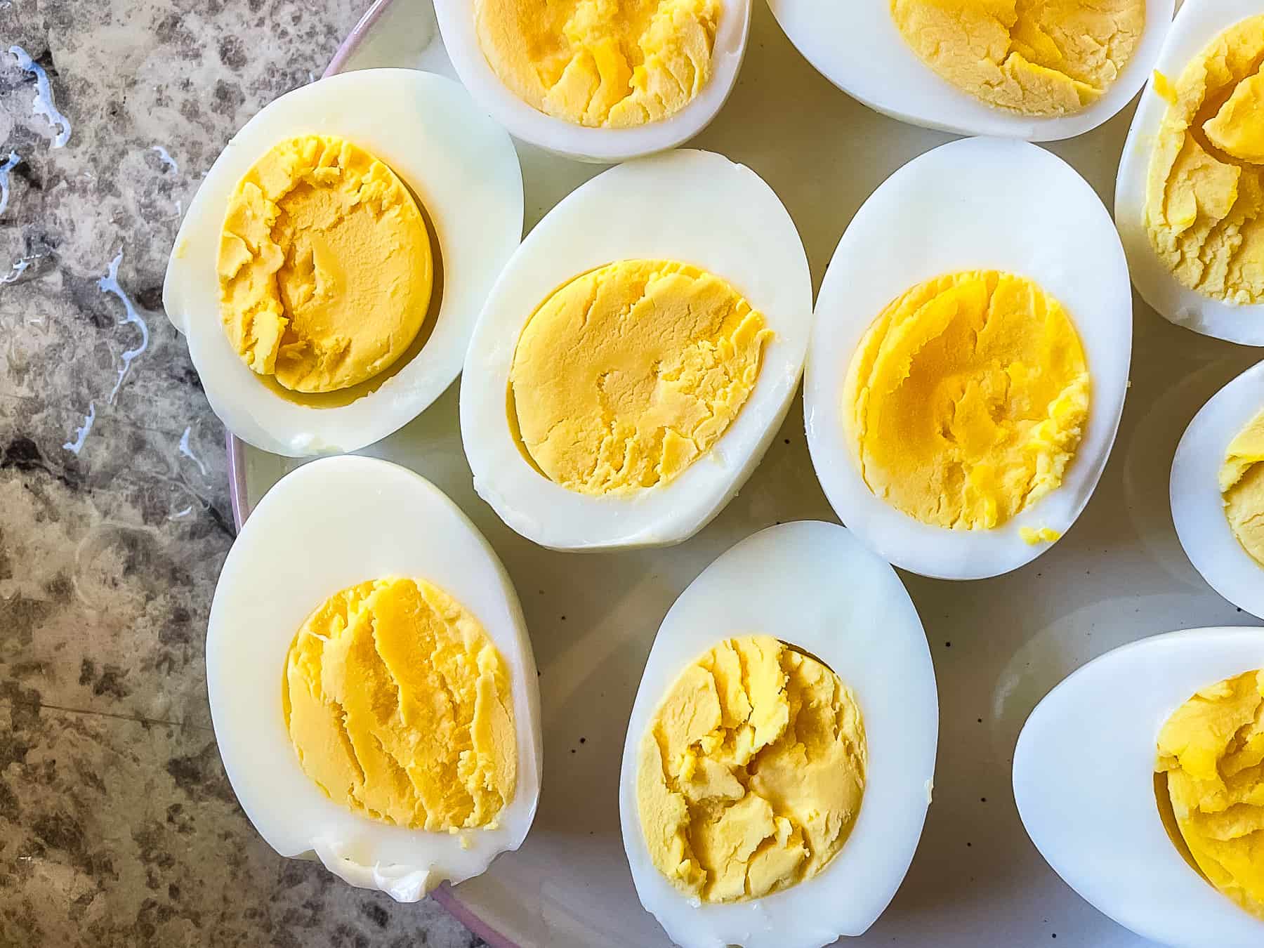 Hard boiled eggs cut in half on a plate.