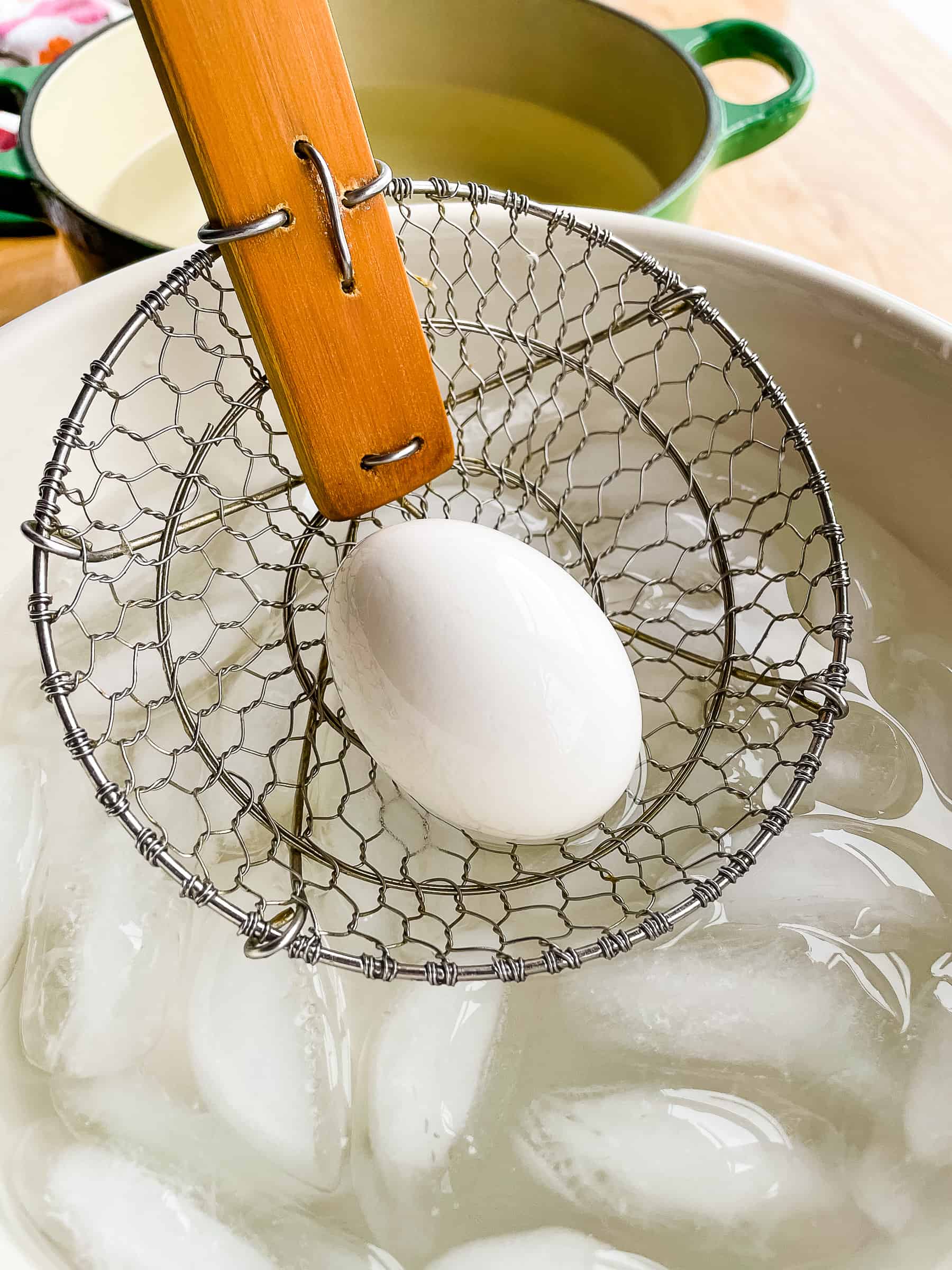 Placing a hard boiled egg in an ice bath.