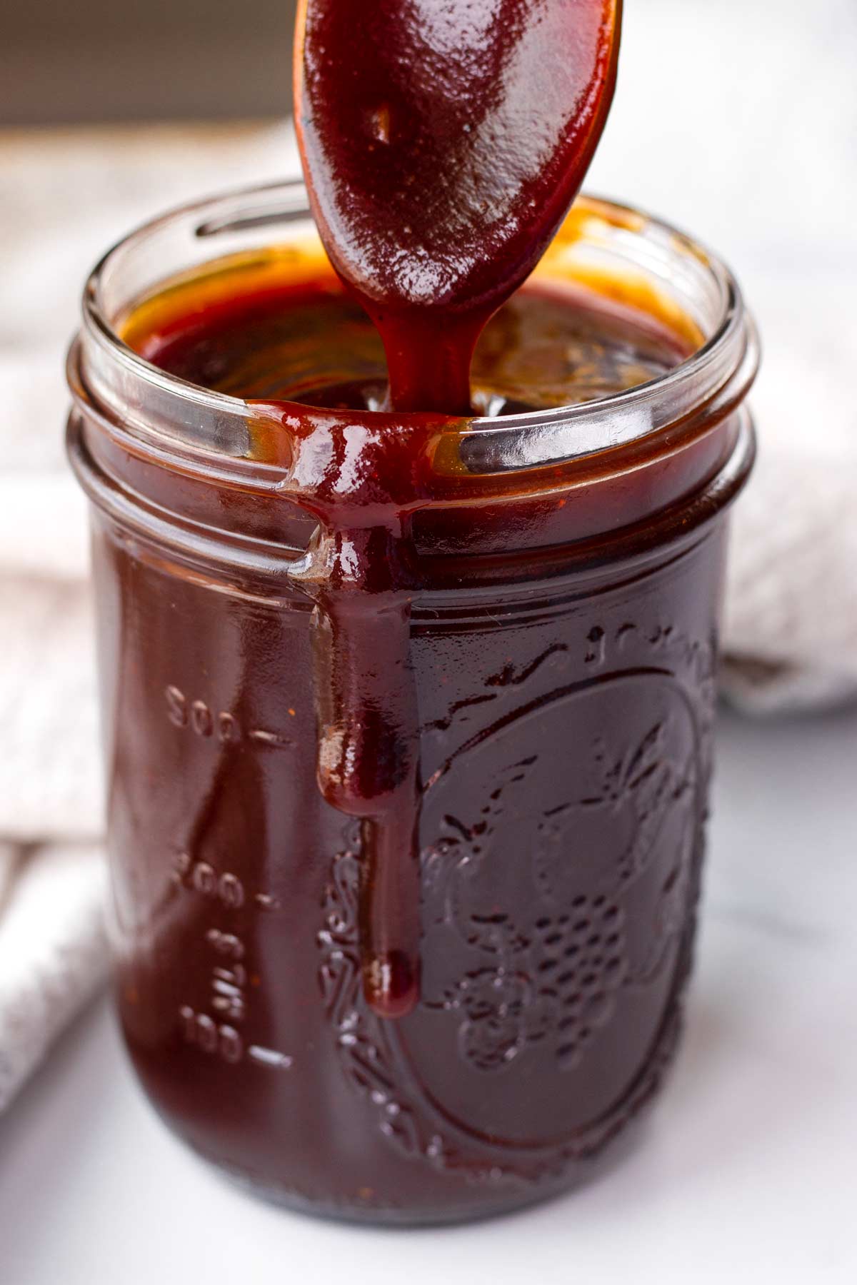 sweet bbq sauce in a mason jar with a spoon