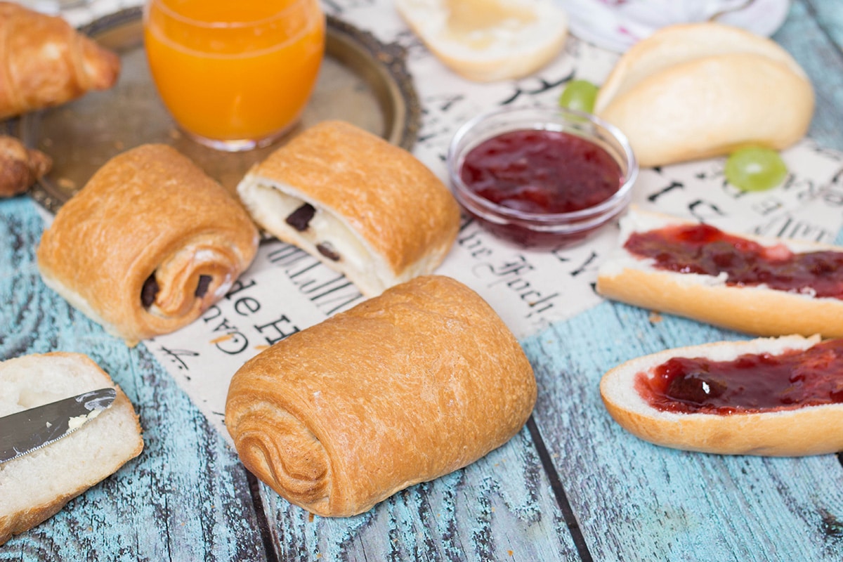 A look at the famous French breakfast, featuring a selection of breads and toppings, croissants, Pain au chocolat, and other goodies! | cookingtheglobe.com