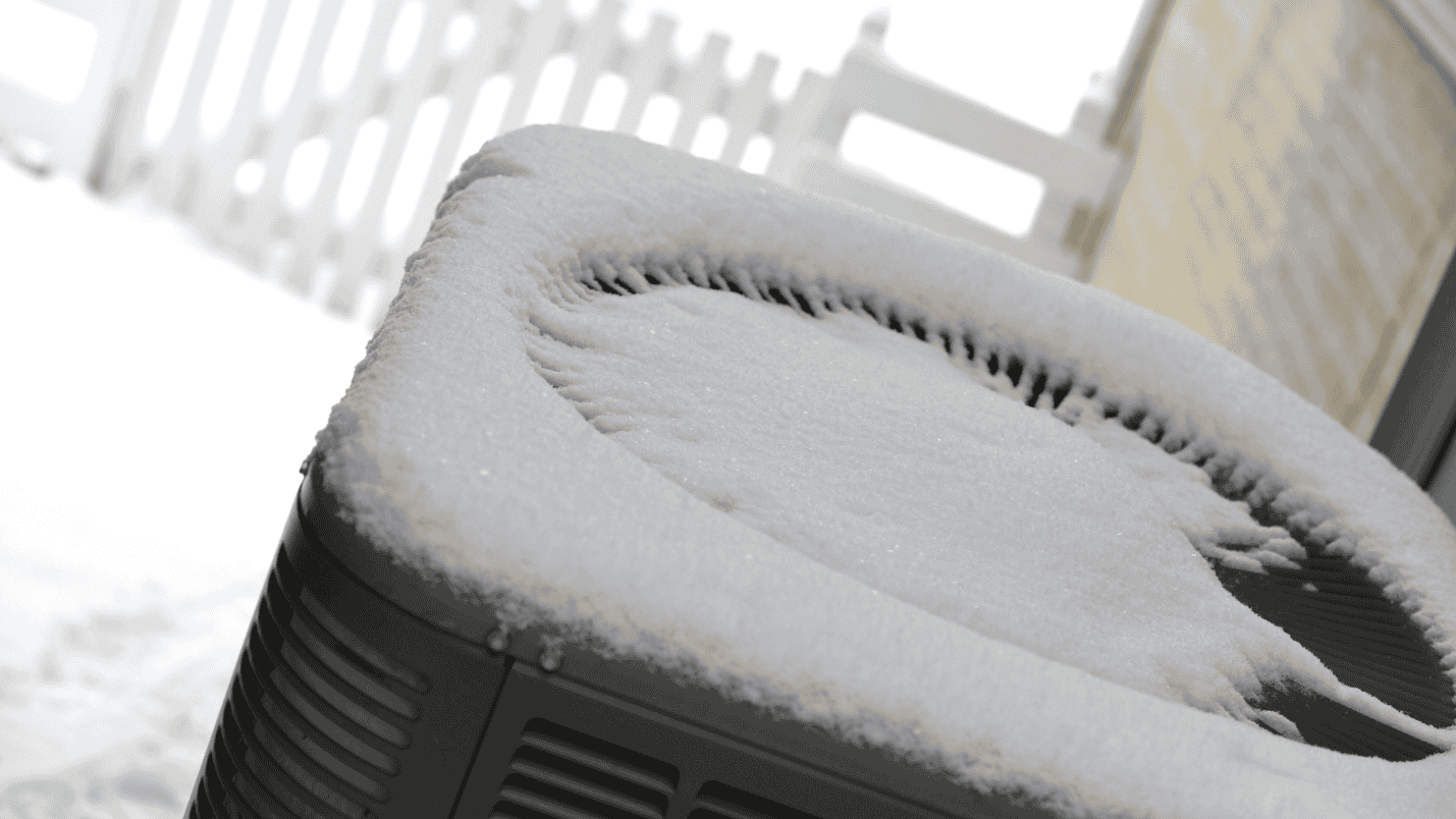 A generator outside, covered with a layer of snow.