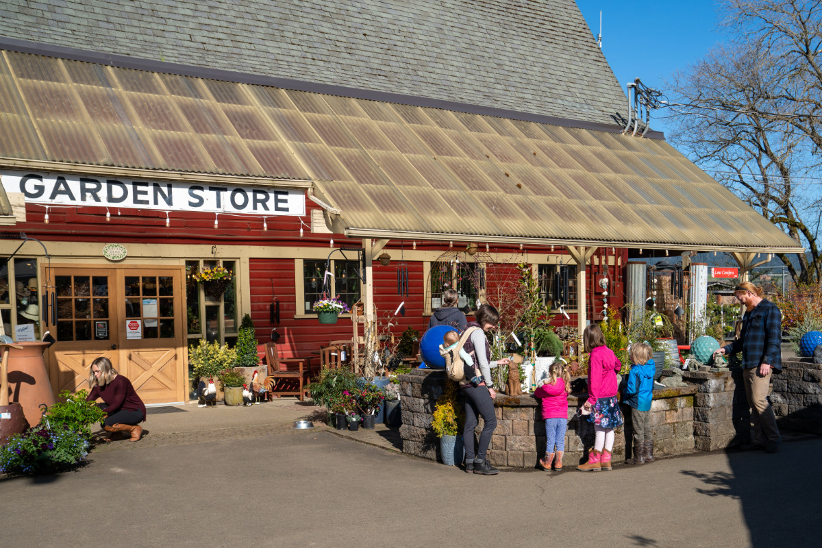 Garland Nursery, Corvallis, Oregon - A young family browses plants and garden decor for sale in front of Garland Nurserys garden store.