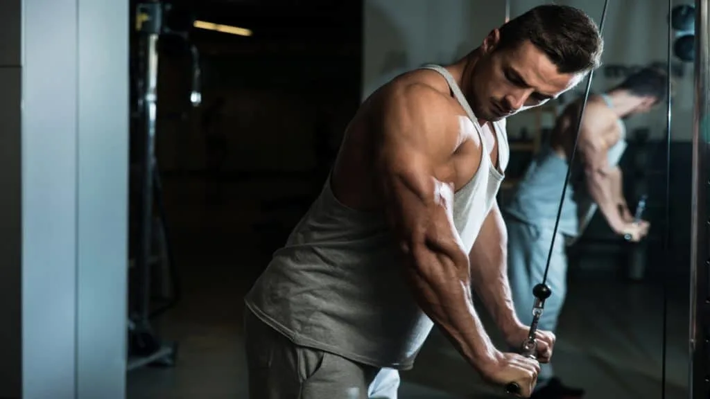 A man with short triceps insertions doing pushdowns at the gym