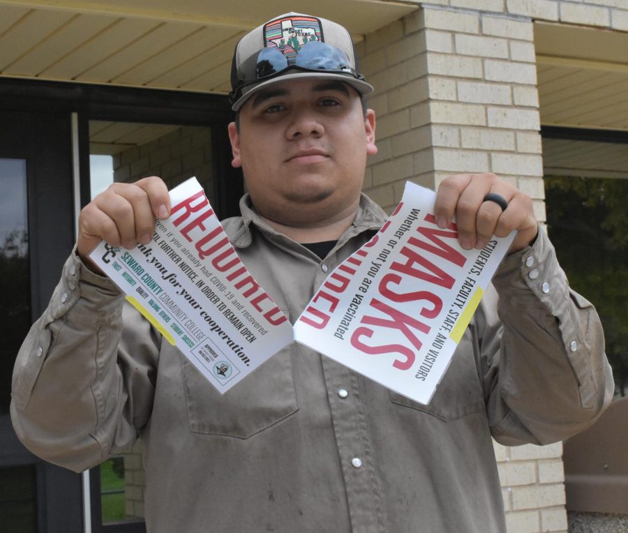 Abel Ochoa rips up the masks are required sign after the announcement that masks are now optional. 