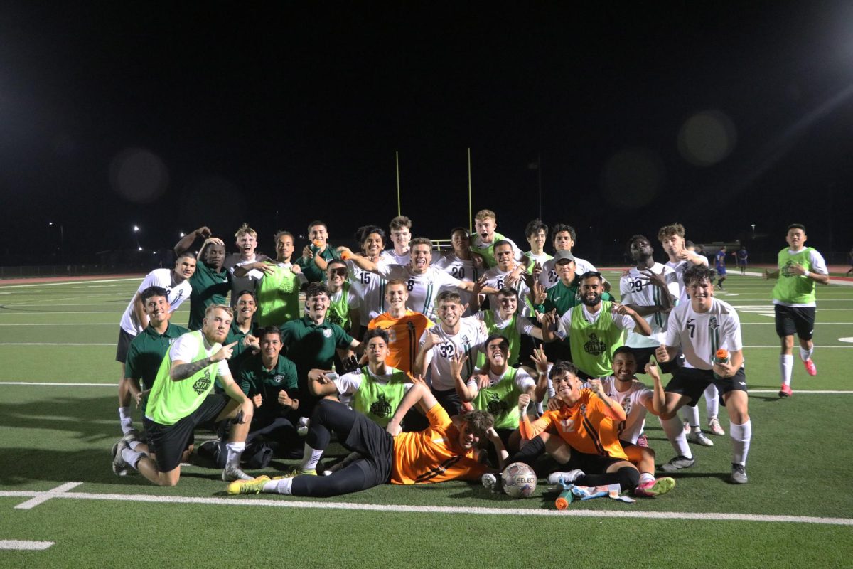 Saints soccer team joyfully posing after a home win. 