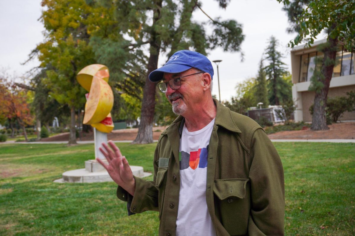 James Deitz, standing and smiling outside of the art department at Stan State.