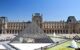 External biew of the front of the museum building, with the glass pyramid in the foreground