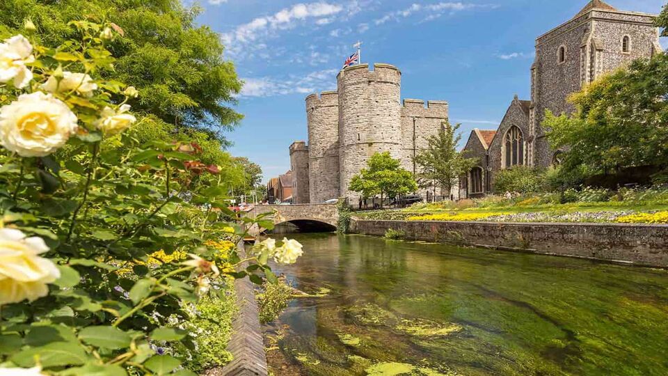 Grass-banked river lined with medieval city walls