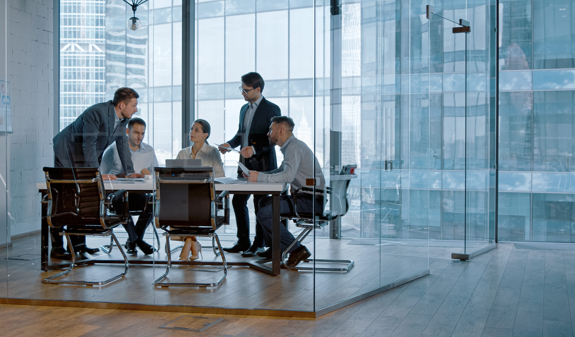 employees in a glass meeting room