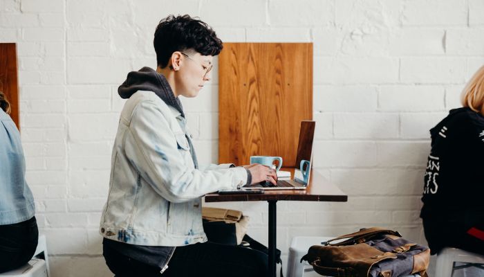 Mujer leyendo en su notebook la diferencia entre publicidad y propaganda.