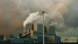 A wind turbine is photographed in front of a factory | Photo: Tim Van der Kuip/Unsplash