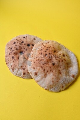 Arabic white bread, freshly baked, placed on a yellow background