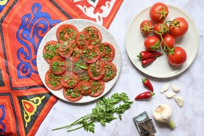 Plate of pickled tomatoes with parsley, besides garlic, red pepper, Egyptian pickles, Arab restaurants