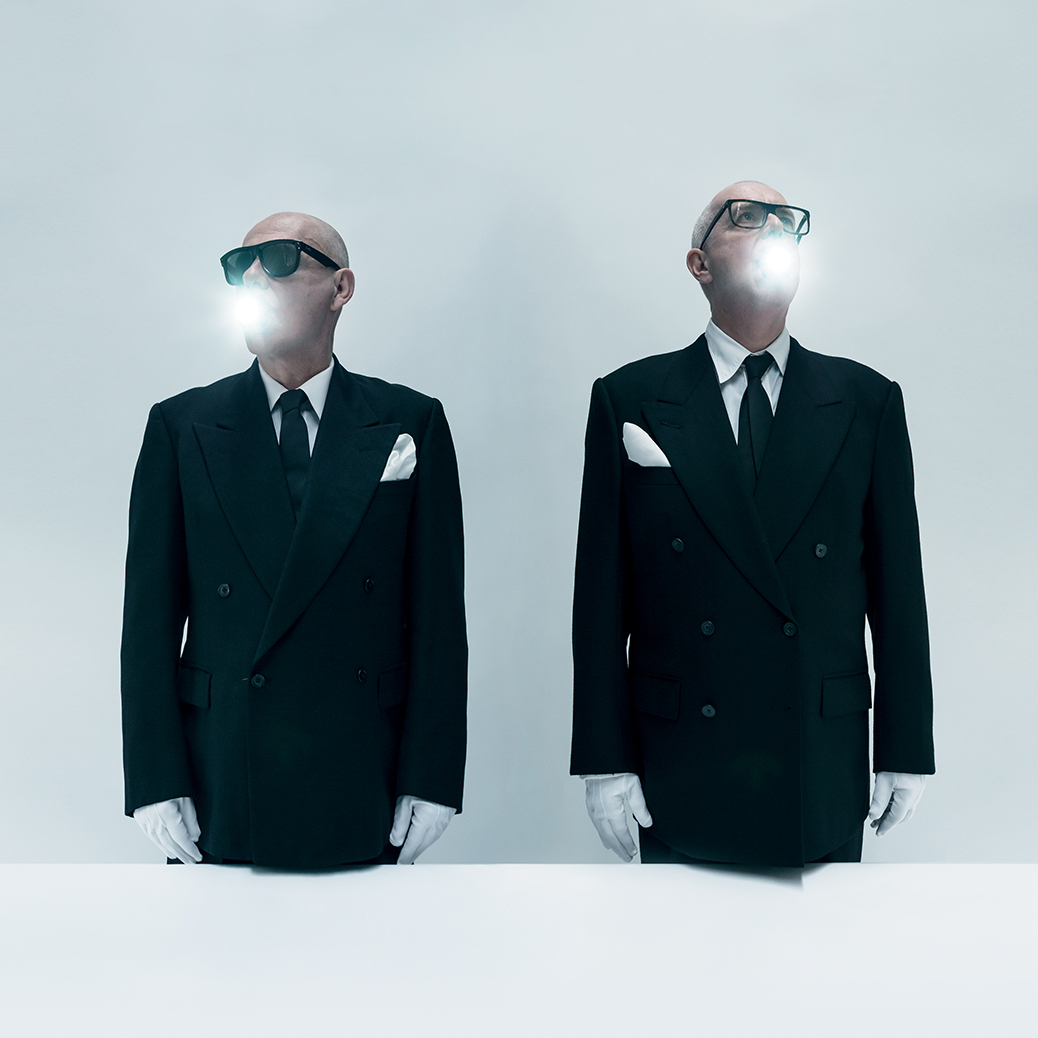 Chris Lowe and Neil Tennant in black suits and sunglasses with light coming out of their mouths