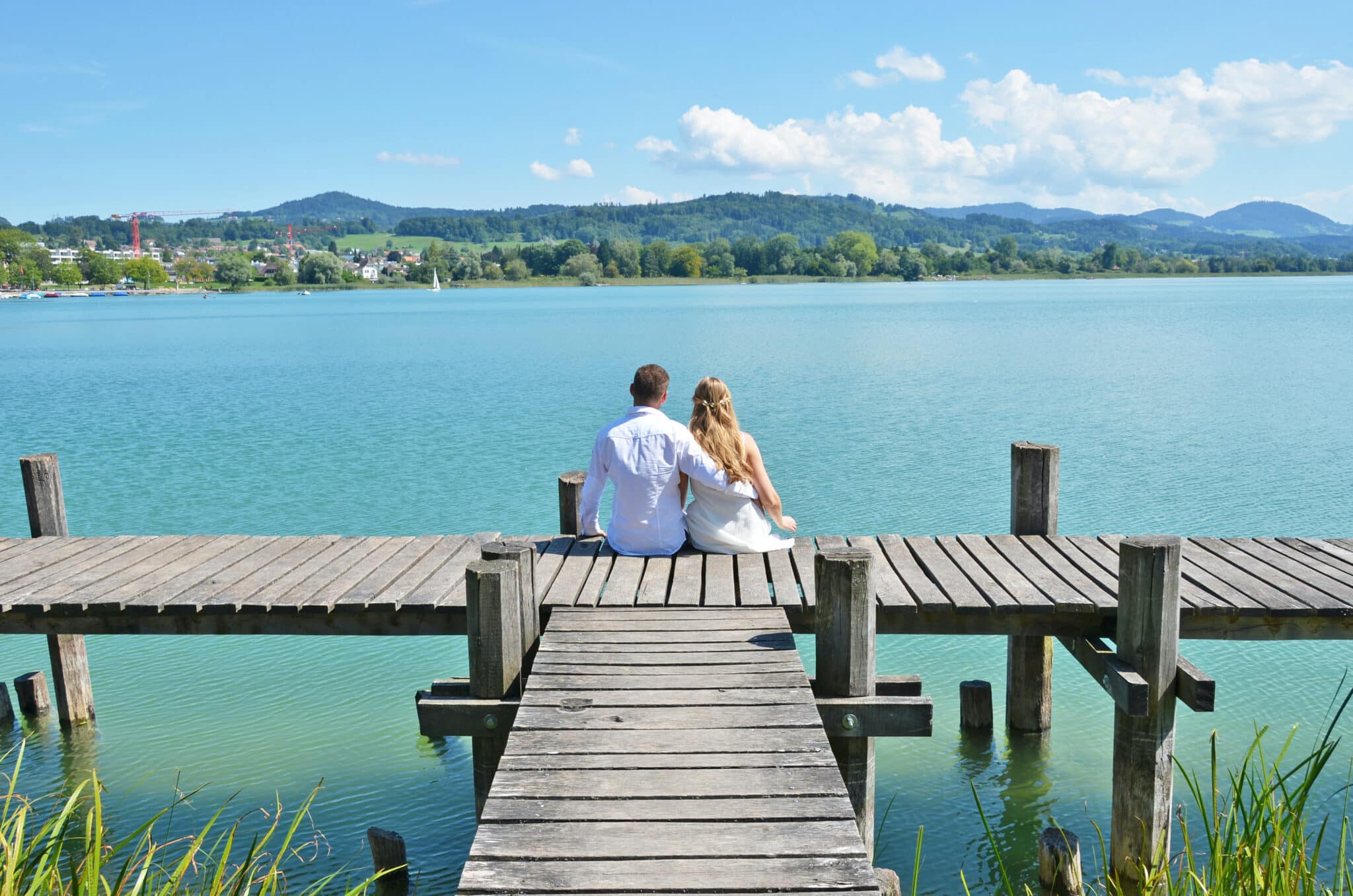 A couple on the wooden jetty at the lake. Switzerland